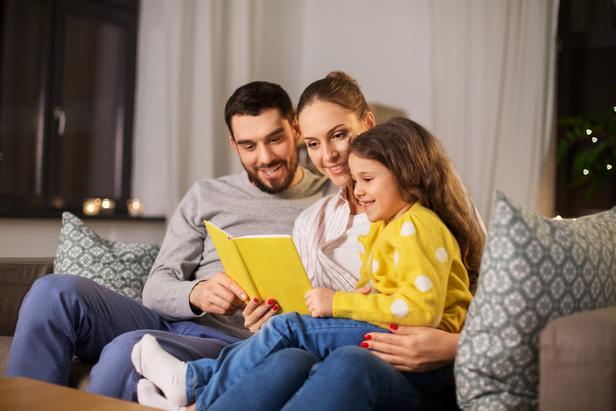 Happy Family Reading a Book Together at Home